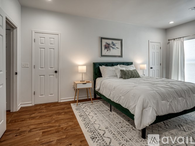 A bedroom with a bed, a nightstand, and a rug.