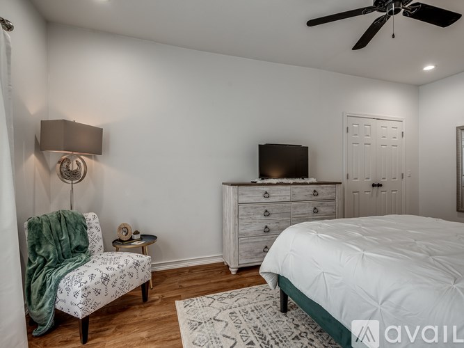 A bedroom with a bed, dresser, and chair.