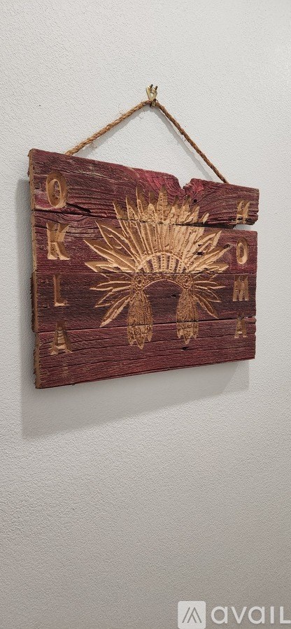 A wooden sign with the letters K-O-M-E-N-T-A-C-T-I-O-N is hanging on a wall.