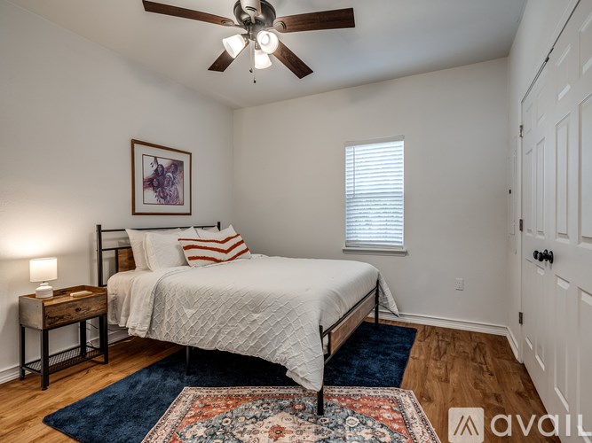 A bedroom with a bed, a ceiling fan, and a rug.