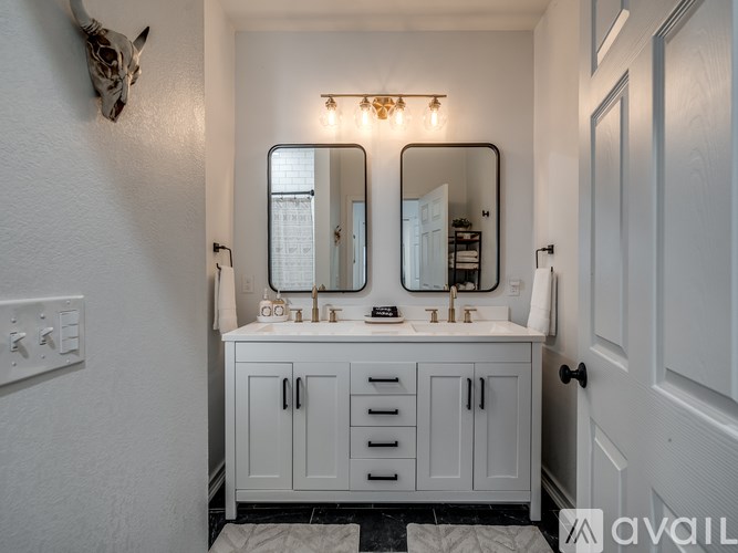 A bathroom with a white cabinet and a mirror above it.