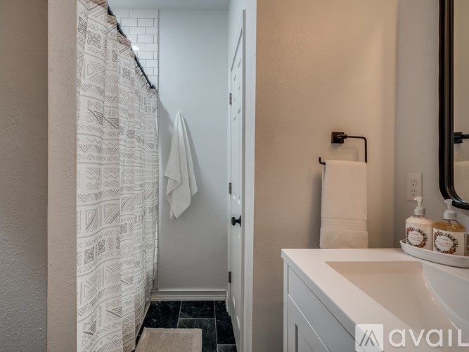A bathroom with a white sink and a shower curtain.