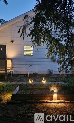 A house with a lit up garden area in front.