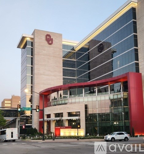 A modern building with a red and white logo on the top.