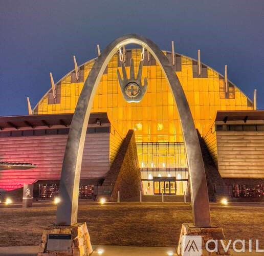 A large building with a circular logo on the front and a large archway in front of it.