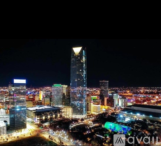 A cityscape at night with a tall building in the center.