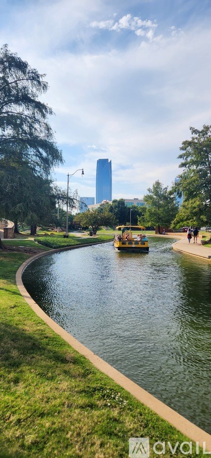 A boat is sailing on a river in a park.