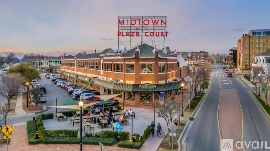 A street view of a plaza with a sign that says "MIDTOWN PLAZA COURT".