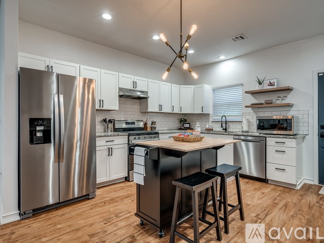 A modern kitchen with a center island and stainless steel appliances.