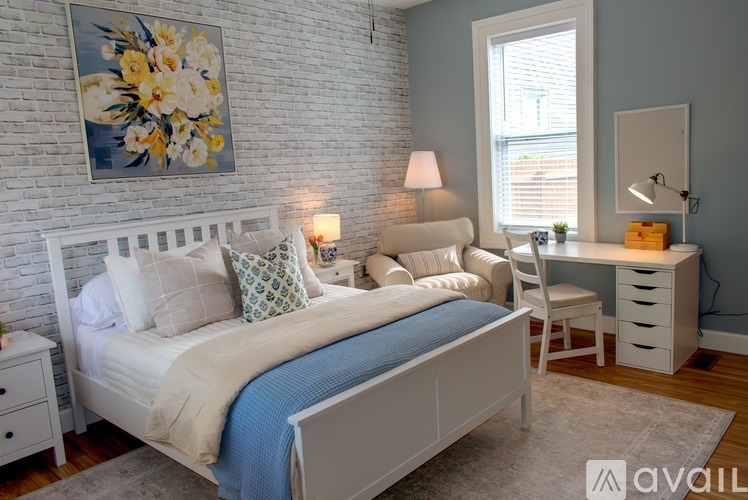 A bedroom with a bed, two doors, and a window.