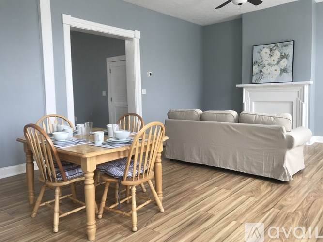 A dining room with a table set for four and a couch.