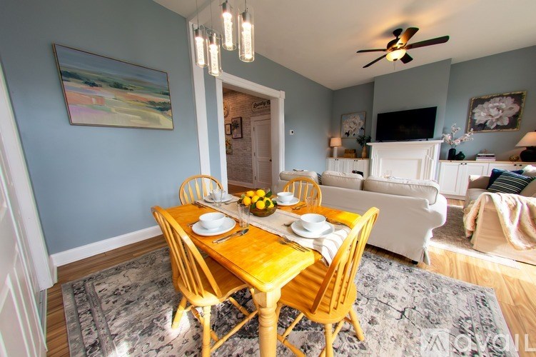 A living room with a couch, chairs, and a table.