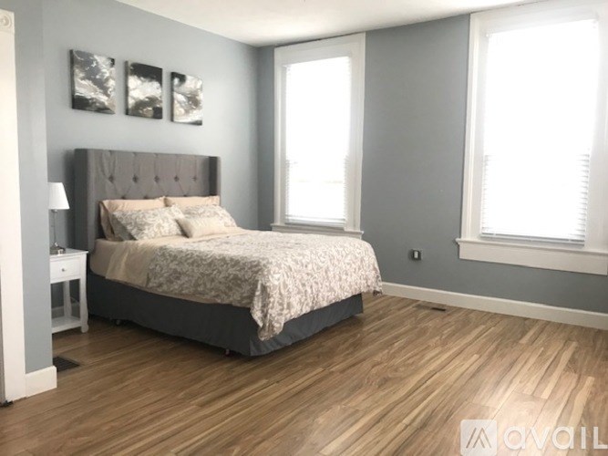 A bedroom with a large bed and a nightstand.