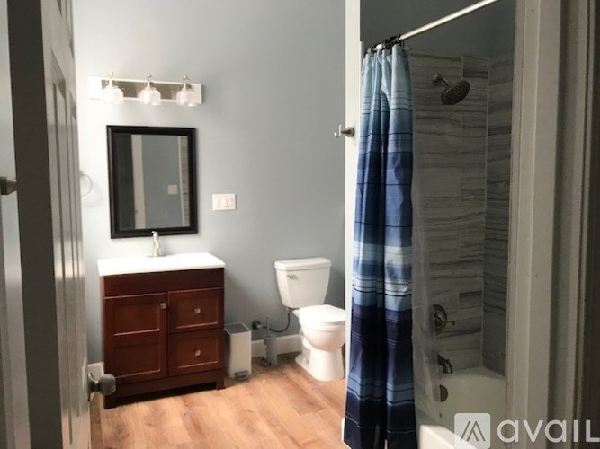 A bathroom with a toilet, sink, and shower.