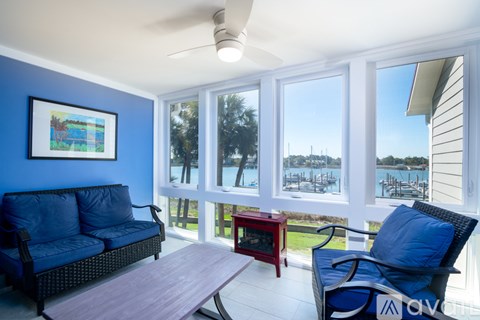 A living room with a blue couch and a ceiling fan.