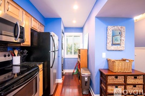 A kitchen with a black refrigerator and stove top oven.