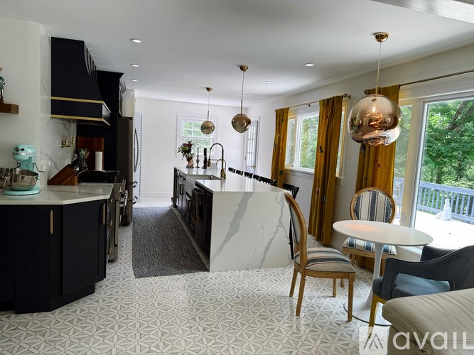 A kitchen with a marble island and wooden chairs.