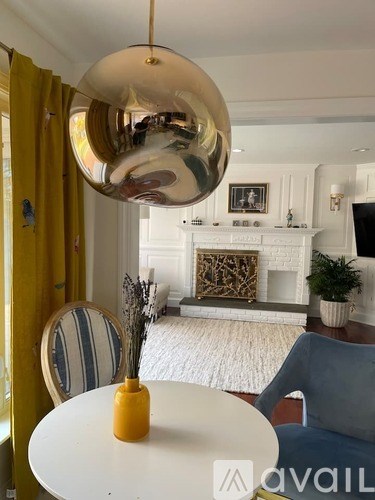 A modern dining room with a white table and a yellow vase on it.