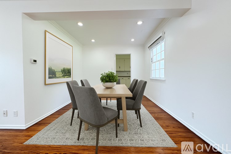 A dining room with a table and chairs.