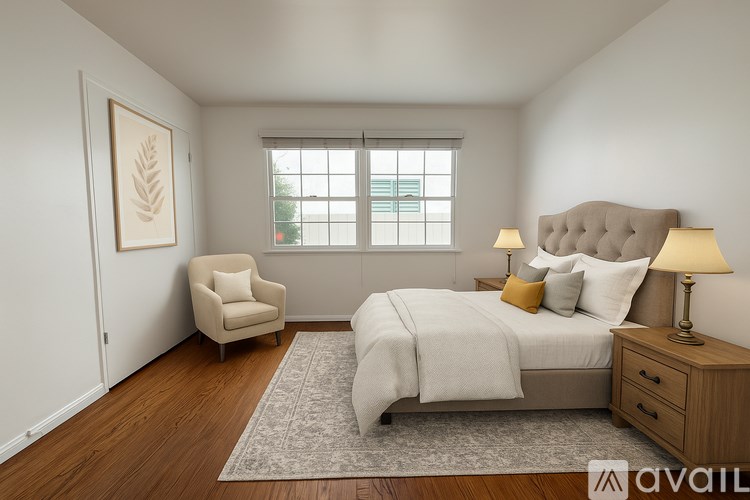 A bedroom with a large bed, a chair, and a window.