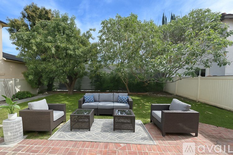 A patio with a sofa, chairs, and a coffee table.