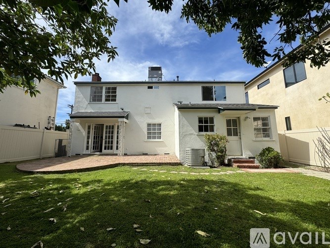 A house with a white exterior and a large front yard.