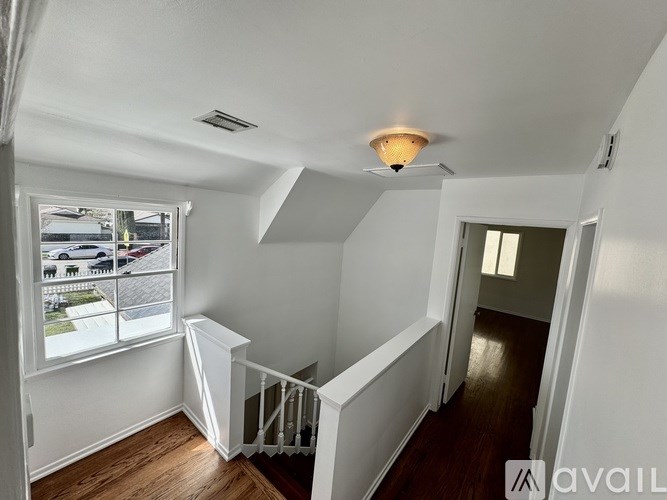 A well-lit, empty room with a window overlooking a street.