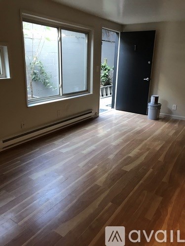A room with wooden flooring and a black door.