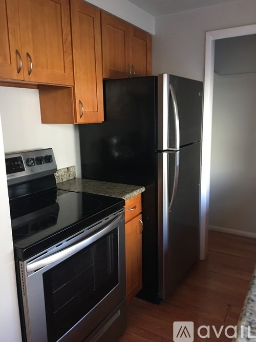 A kitchen with wooden cabinets and a black refrigerator.