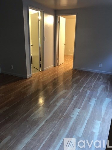 A room with wooden floors and a window with blinds.