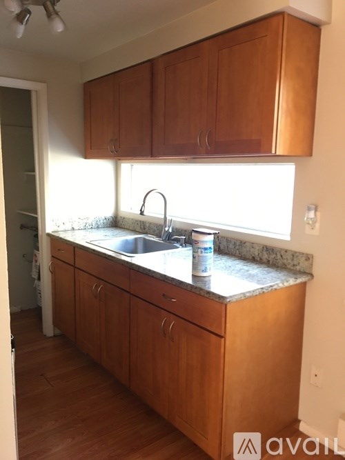 A kitchen with wooden cabinets and a marble countertop.