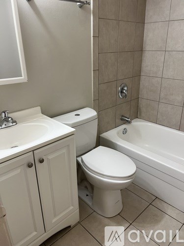A white toilet sits next to a sink in a bathroom.