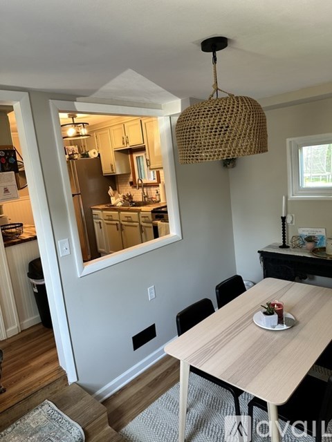 A kitchen with a table and chairs in front of a window.