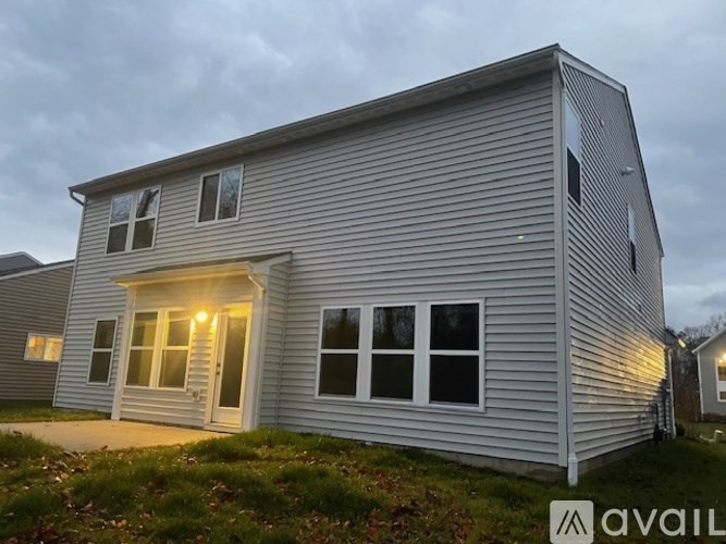 A house with a grey siding and a white door is shown.
