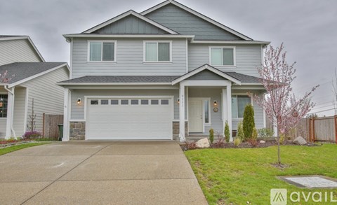 A house with a grey garage door is for sale.