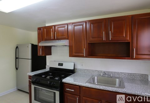 A kitchen with brown cabinets and a black stove top oven.