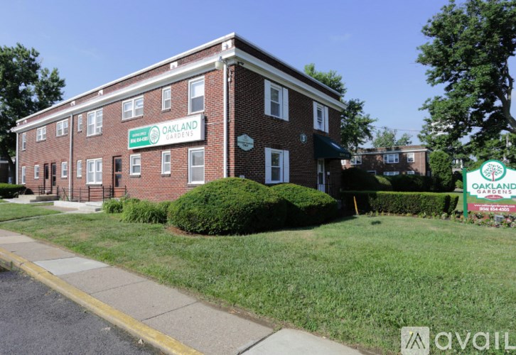 A brick building with a green sign that says Oakland Gardens.