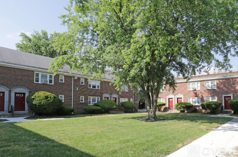 A tree in front of a red brick building.