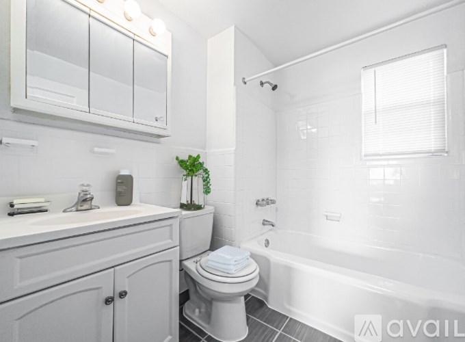 A white bathroom with a toilet, sink, and bathtub.