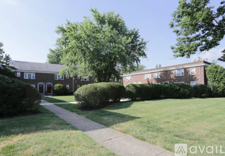 A grassy area in front of a building with a walkway leading to it.