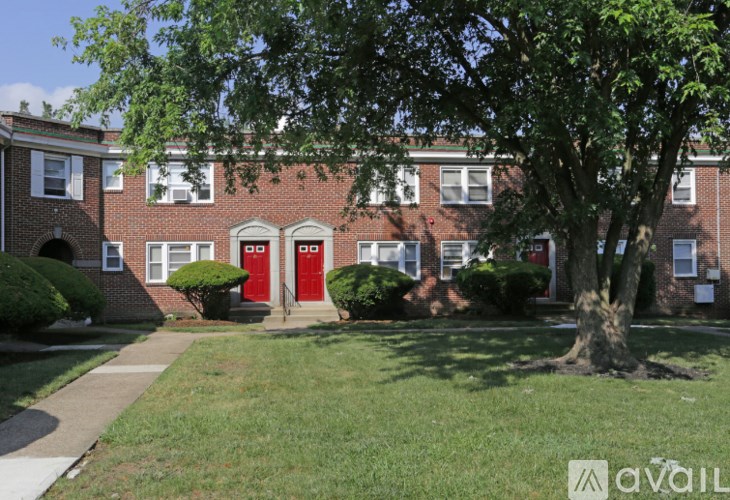 A tree in front of a red brick building.