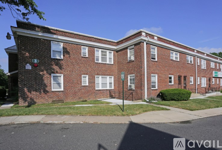 A red brick building with a green lawn in front.