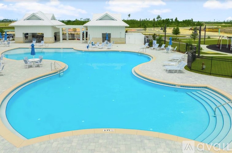 A large outdoor swimming pool with a slide and sun loungers.