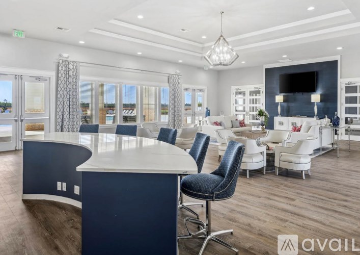 A modern living room with a curved white and dark blue table and chairs.