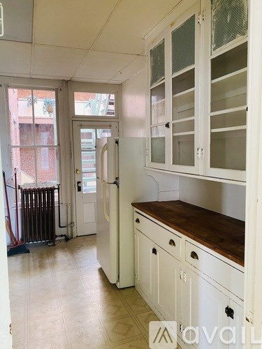 A kitchen with white cabinets and a wooden countertop.