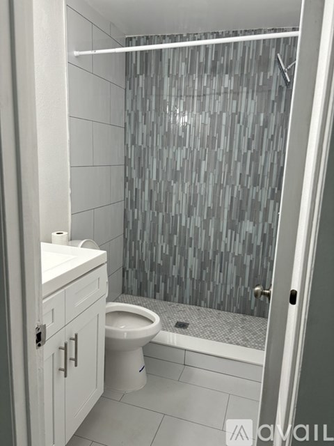 A bathroom with a toilet, sink, and shower.