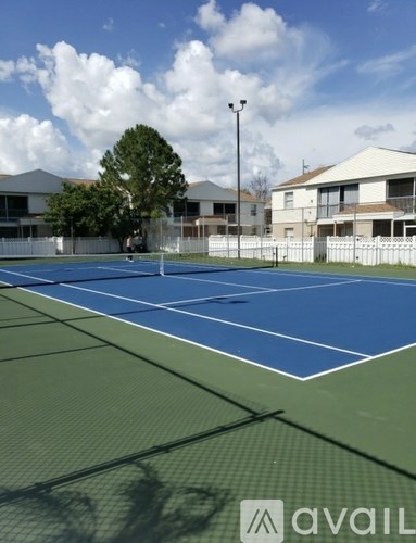 A tennis court with a blue top surface and green bottom surface.