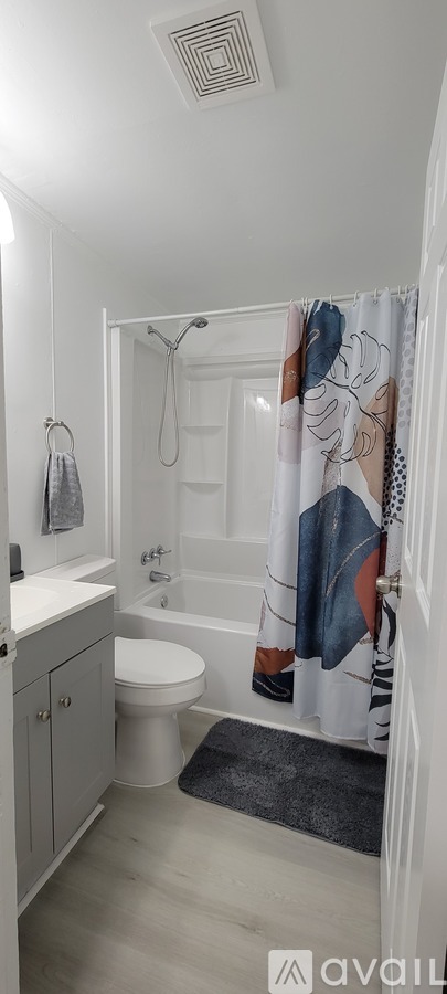 A bathroom with a toilet, sink, and shower.