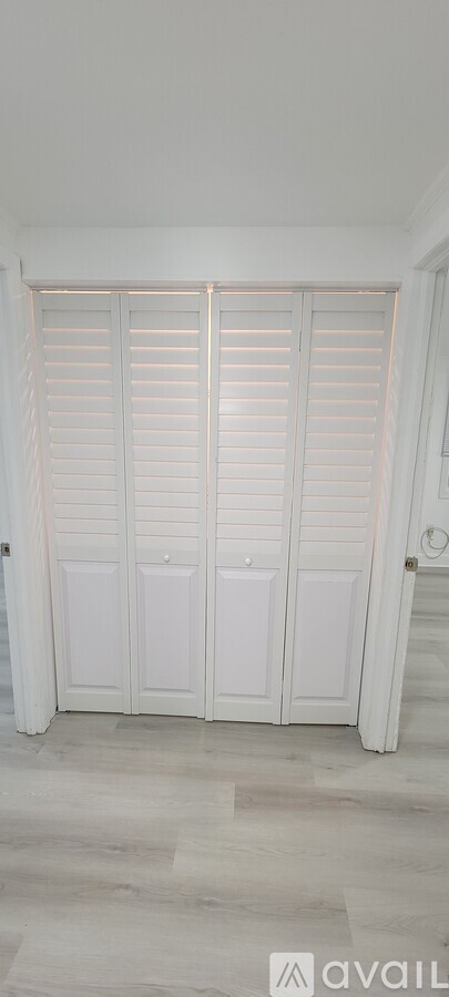 Closed white shutter doors in a room.