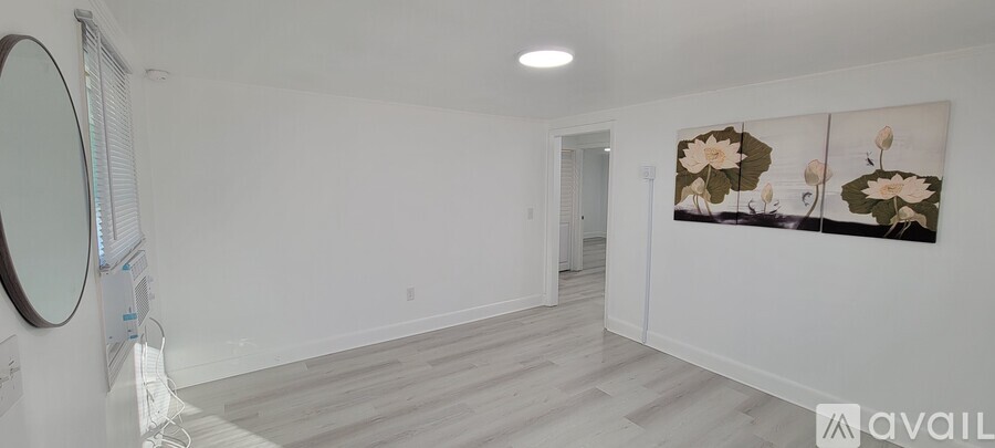 A spacious room with a large painting of flowers on the wall.